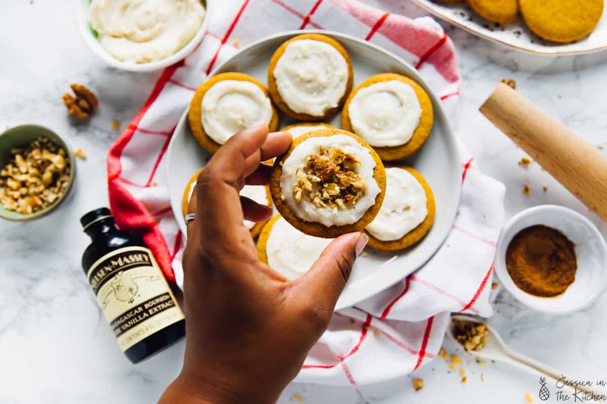 A hand holding a pumpkin spice cookie. 