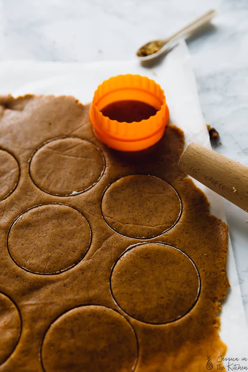 Cutting cookie dough into circles from a sheet of dough. 
