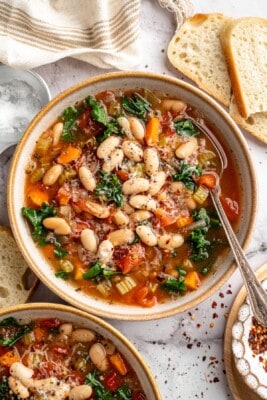 Overhead view of white bean and kale soup in bowl with spoon