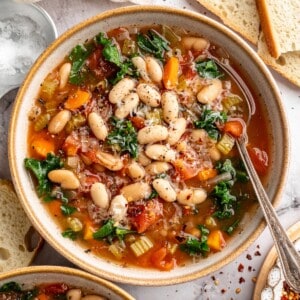Overhead view of white bean and kale soup in bowl with spoon