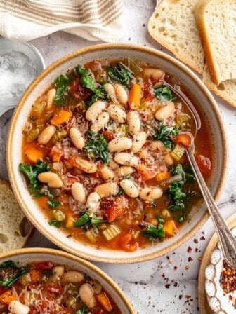Overhead view of white bean and kale soup in bowl with spoon