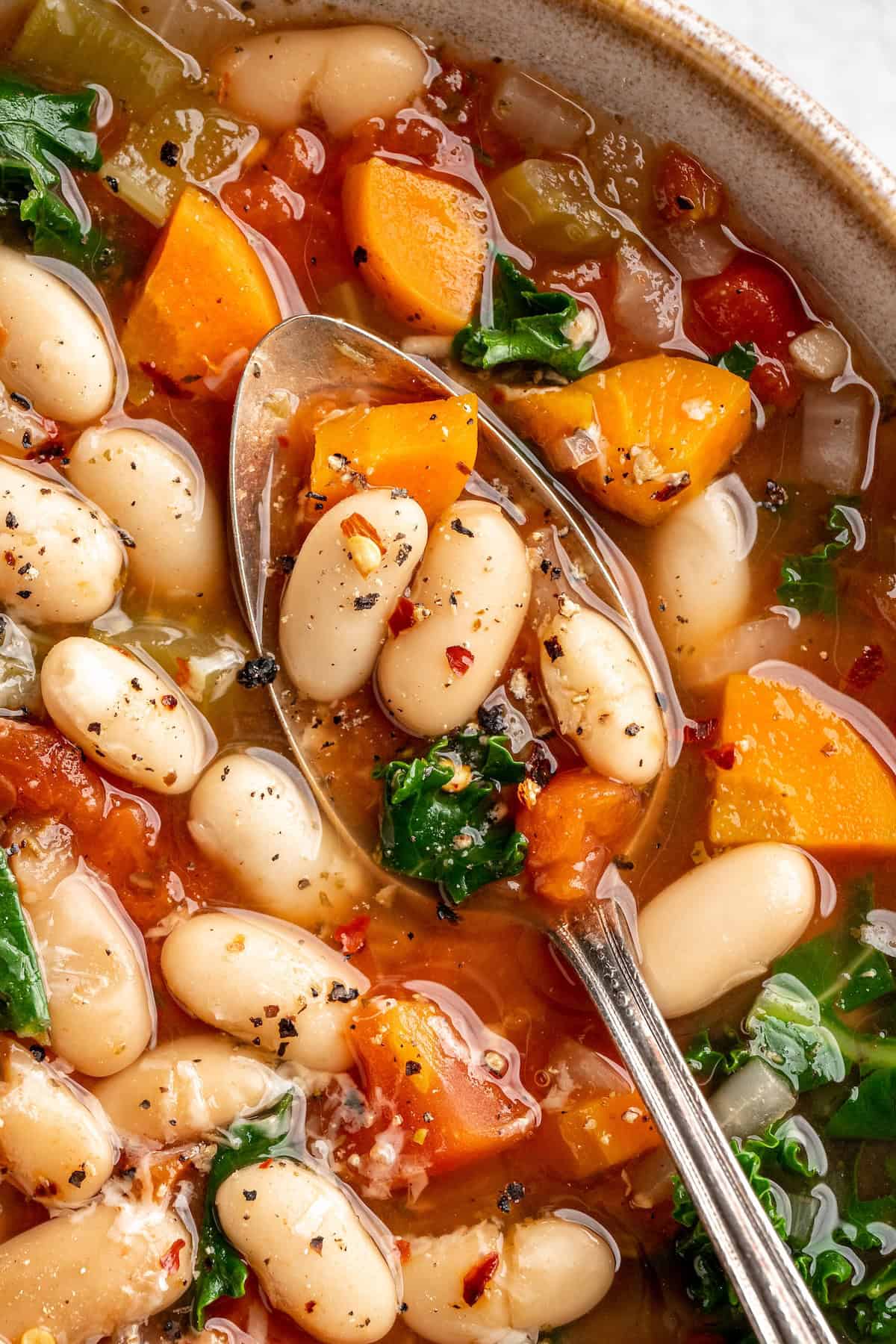 Spoonful of kale and white bean soup in bowl
