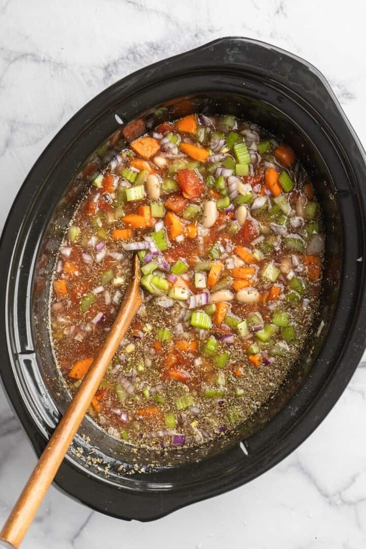 Overhead view of white bean and kale soup in slow cooker
