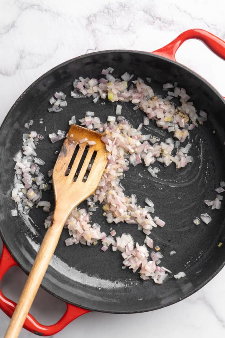 Stirring red onions cooking in skillet