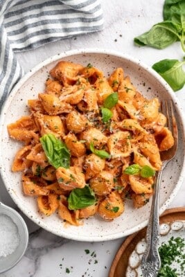 Overhead view of creamy tomato pasta in bowl with fork