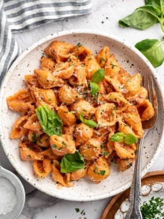 Overhead view of creamy tomato pasta in bowl with fork