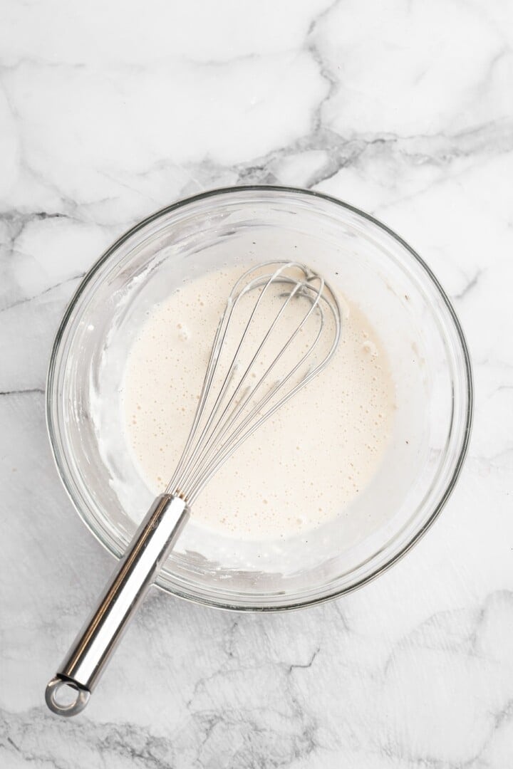 Overhead view of batter for General Tso cauliflower in bowl with whisk