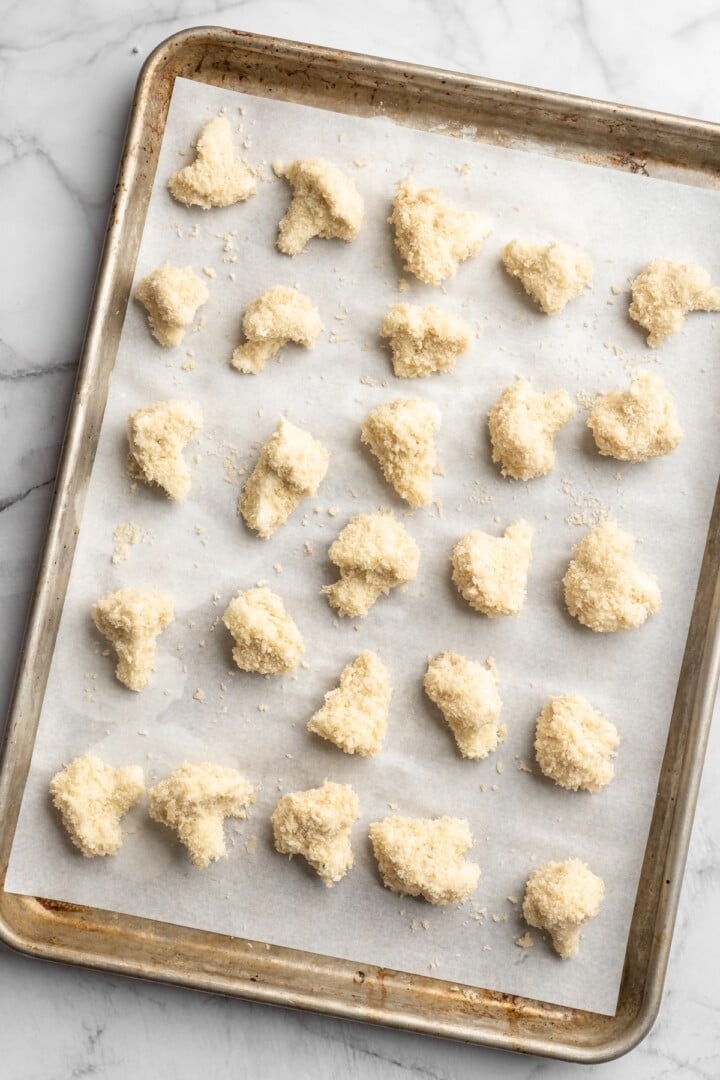 Overhead view of cauliflower with batter on sheet pan