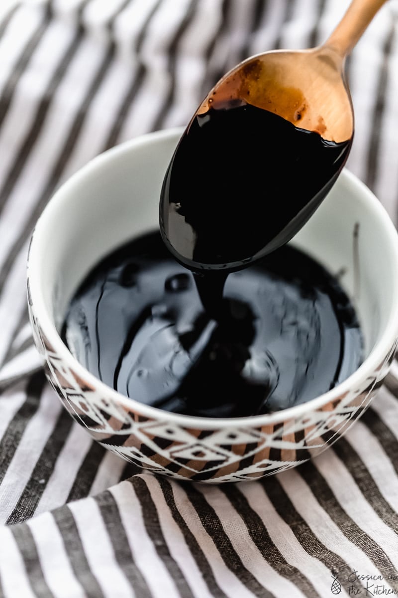 Spoon dripping balsamic glaze into small bowl