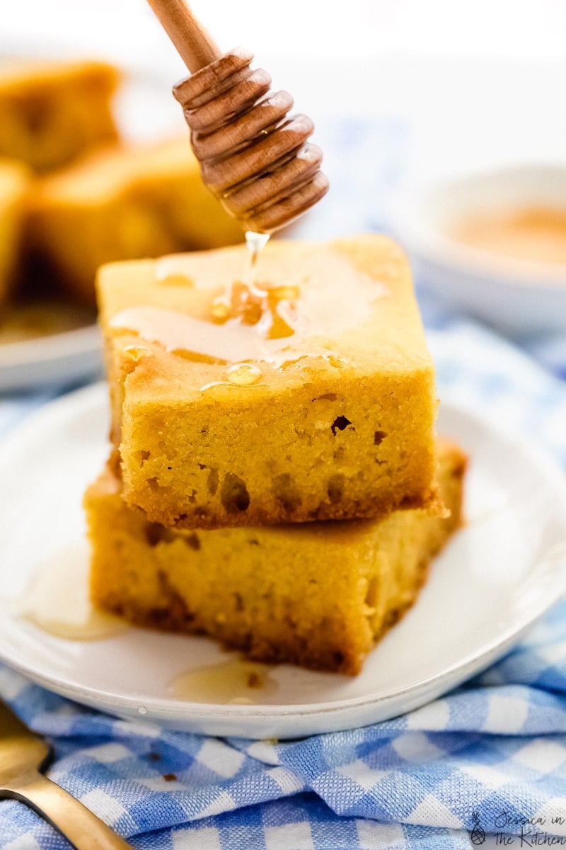 vegan cornbread on a plate with maple syrup drizzling onto it