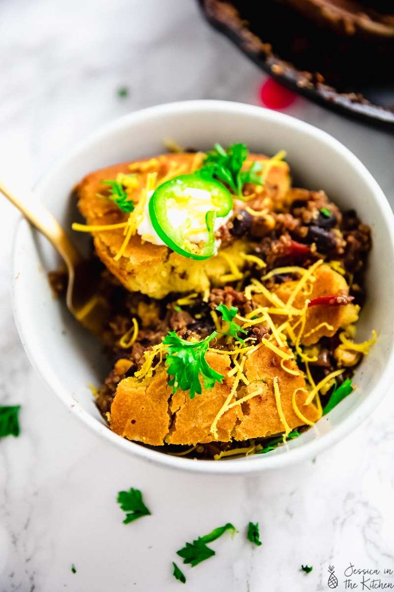 Top down view of cornbread casserole in a white bowl. 