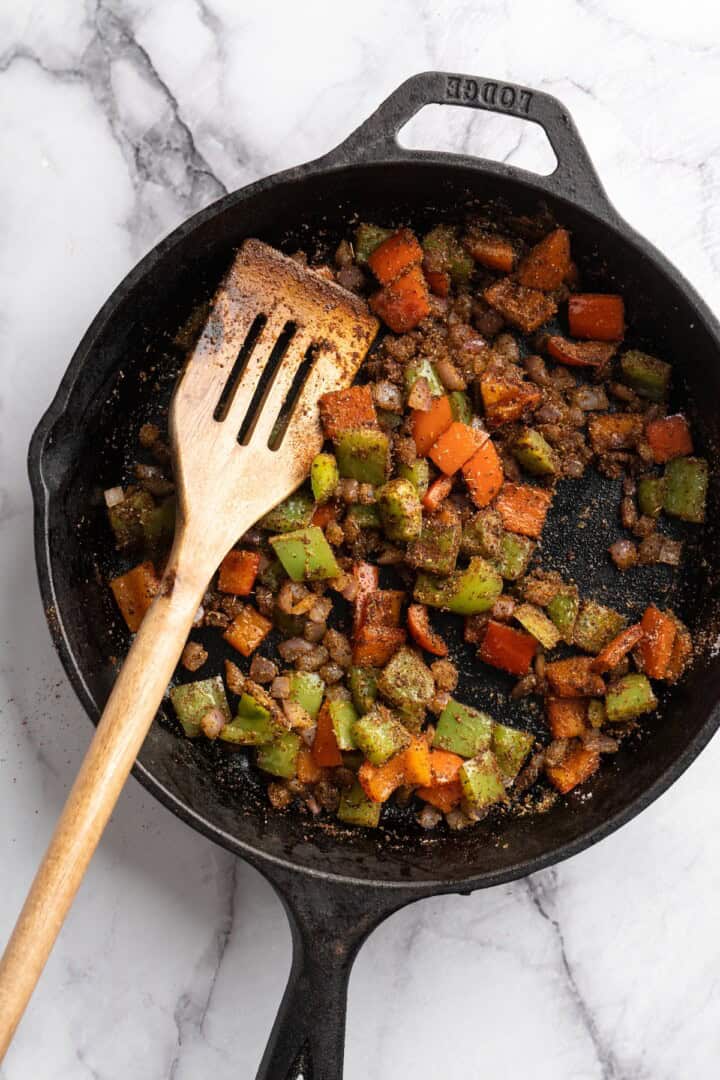This vegan chili cornbread casserole is one of the BEST casseroles ever! The secret? Sweet, crispy cornbread baked on top of delicious chili. Vegetables and seasonings cooking in skillet