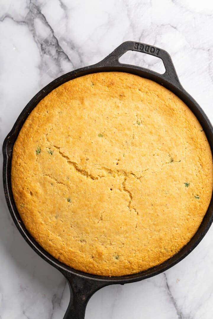 This vegan chili cornbread casserole is one of the BEST casseroles ever! The secret? Sweet, crispy cornbread baked on top of delicious chili. Overhead view of vegan chili cornbread casserole in skillet