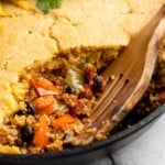 Chili cornbread casserole in pan with wooden spoon