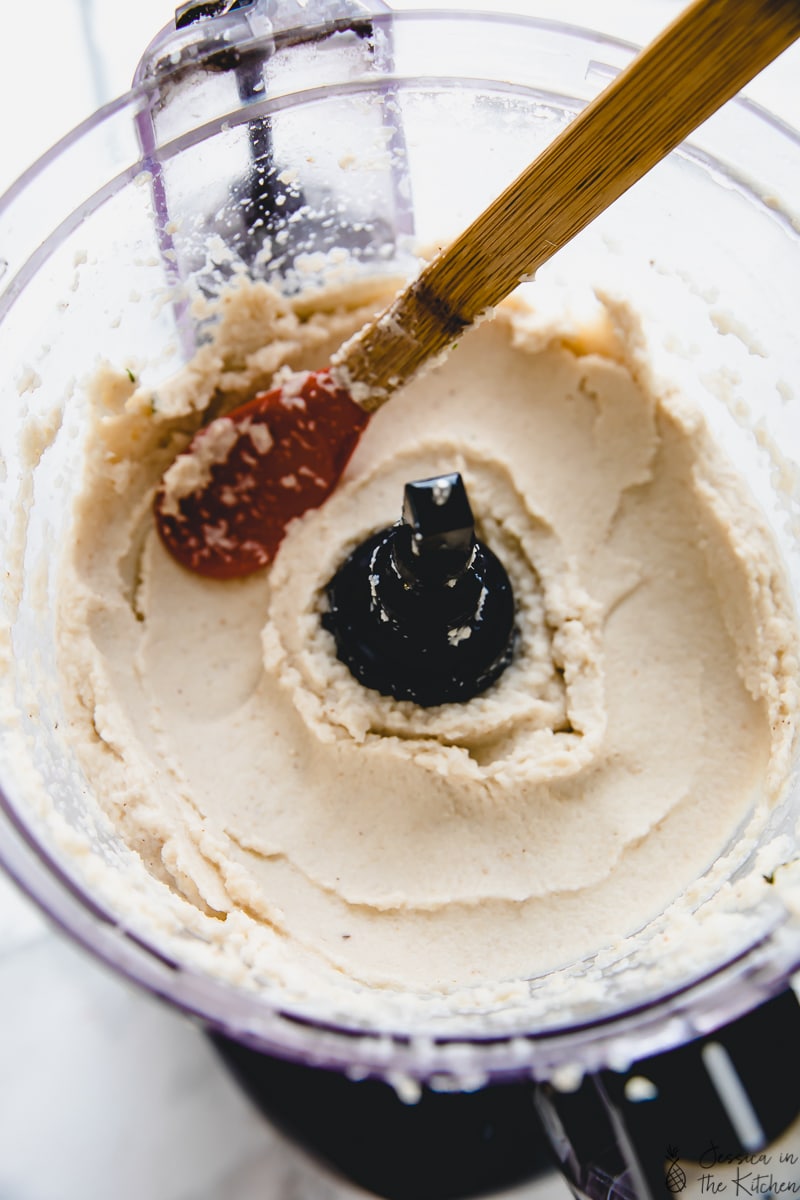 Stirring cauliflower mash in a food processor. 