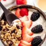 A bowl of vegan yogurt, topped with berries.