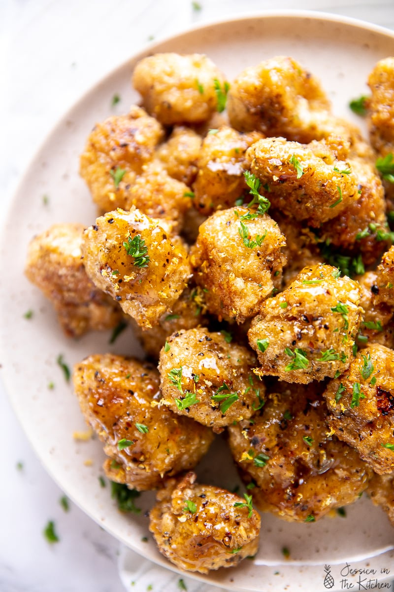 Top down view of lemon pepper cauliflower wings on a plate. 