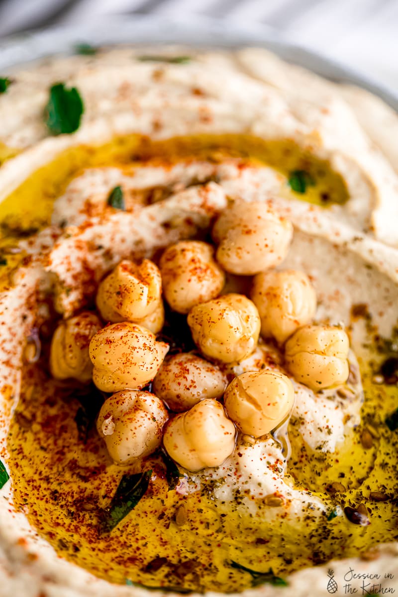 Close up of chickpeas on hummus flecked with za'atar and paprika