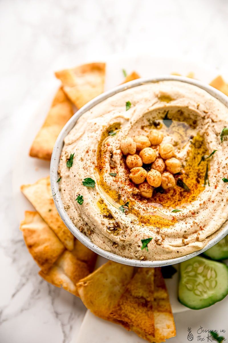 Bowl filled with homemade hummus, topped with olive oil, za'atar, and chickpeas