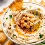 A bowl of hummus topped with chickpeas.