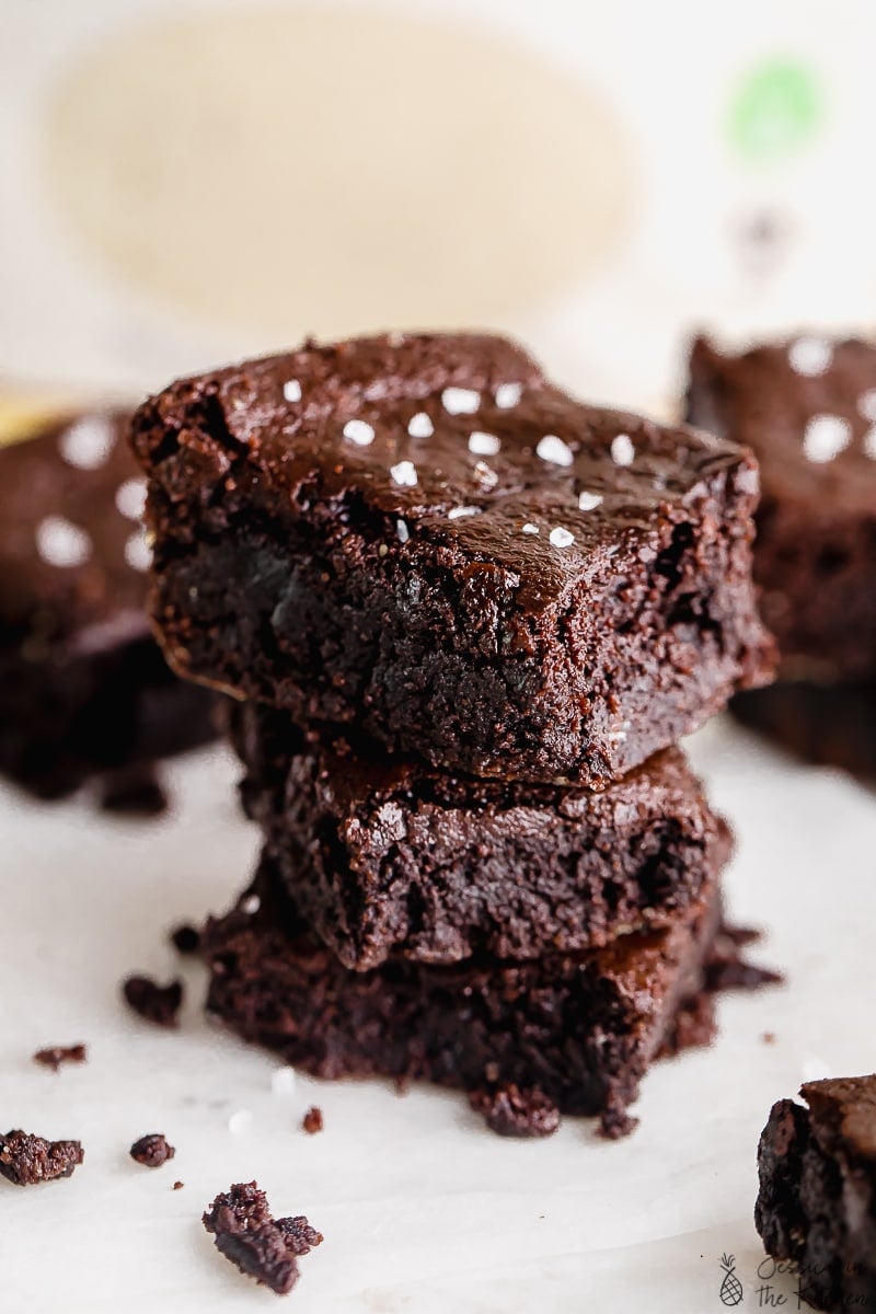 Posizione ravvicinata di brownies vegani alla farina di mandorle impilati con sale spruzzato.