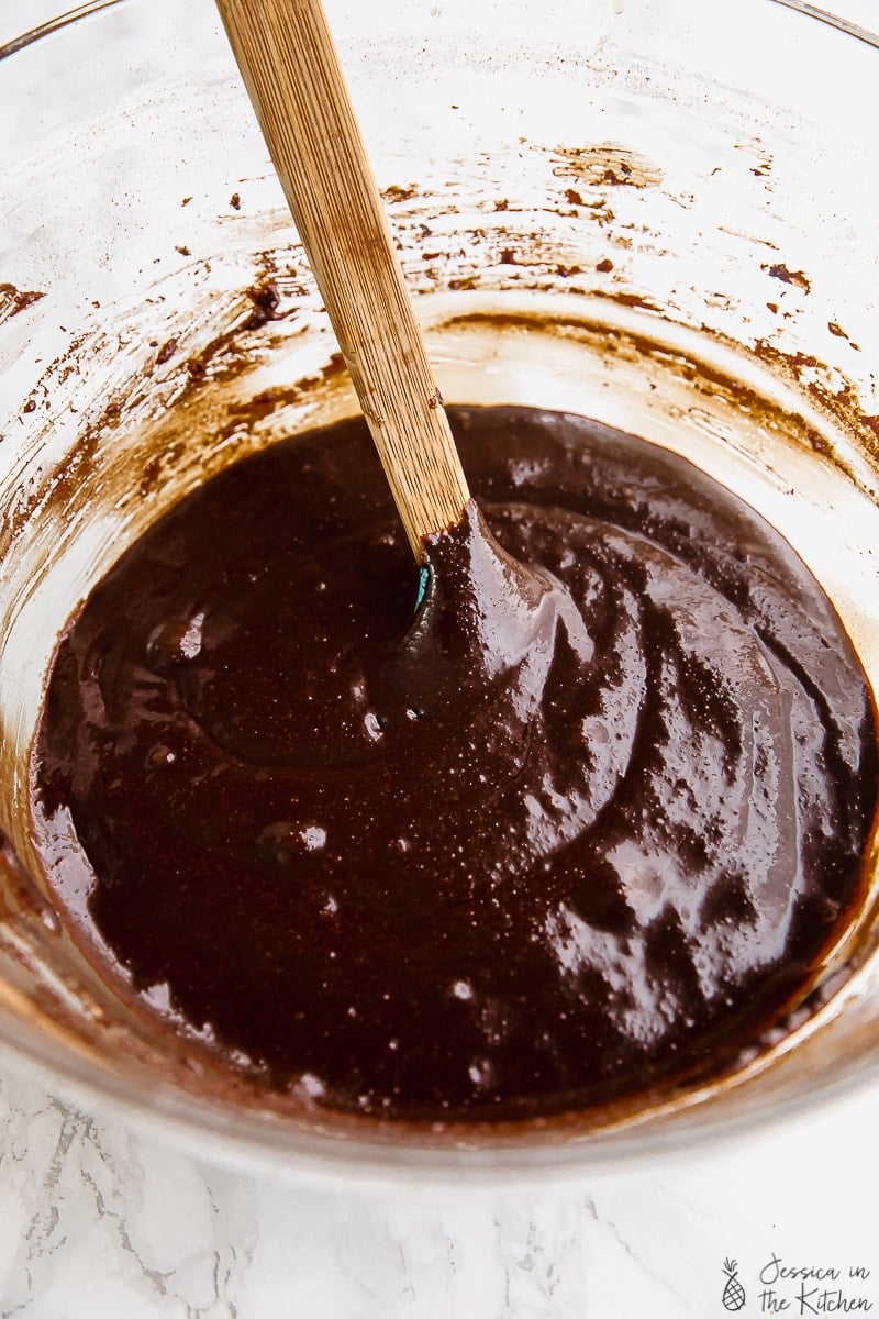 Vegan almond flour brownie batter in bowl with spoon stuck in the middle.