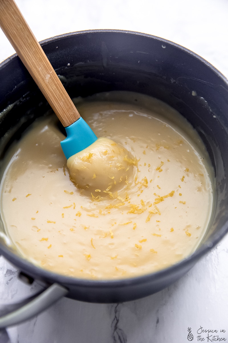 A spatula stirring a pot of vegan lemon curd.