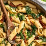 Skillet of sun-dried tomato and spinach hummus pasta.