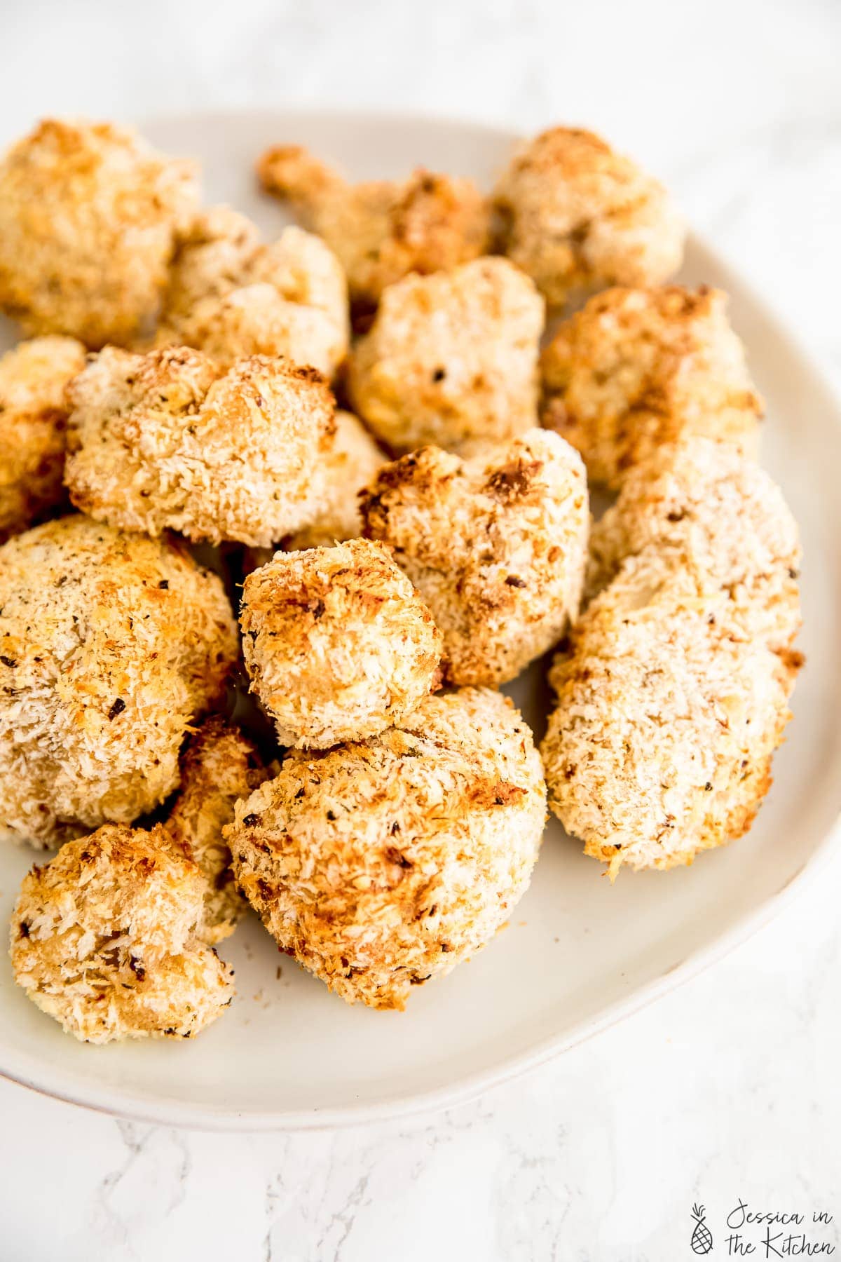 Breaded and baked cauliflower wings on a plate.