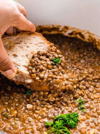 Bread dipped into a pot of lentil stew.