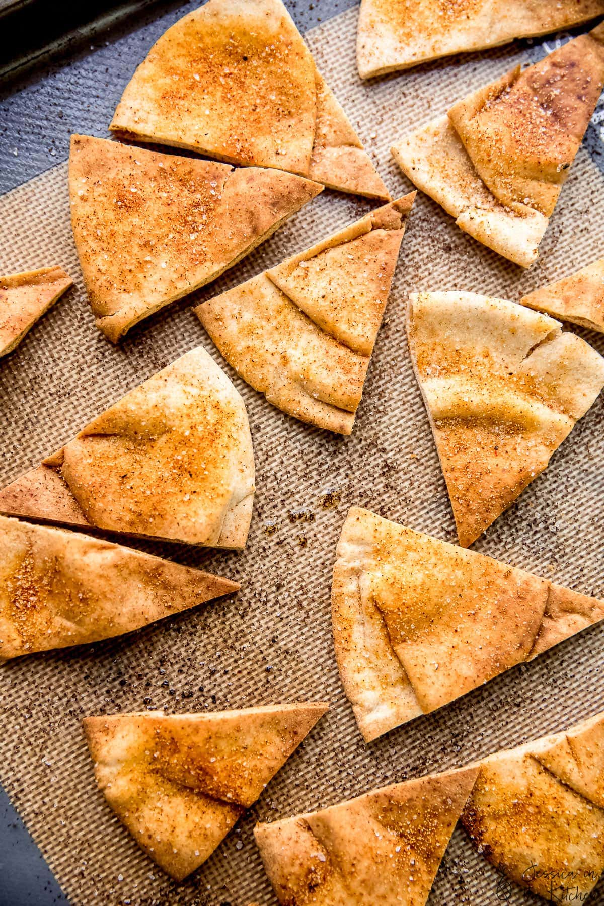 Homemade pita chips in on a baking sheet.