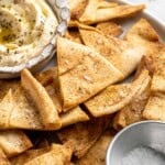 Homemade pita chips with bowl of hummus.