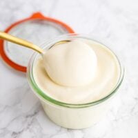 Vegan mayo being scooped out of a jar.