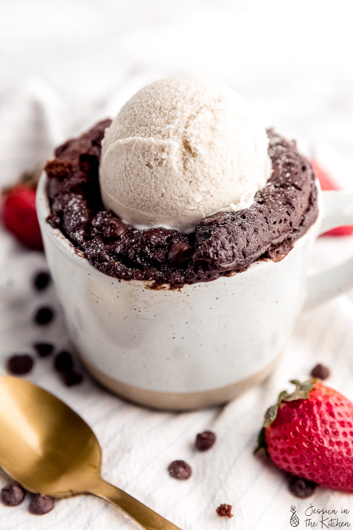 Close up photo of mug cake with a scoop of ice cream on top.