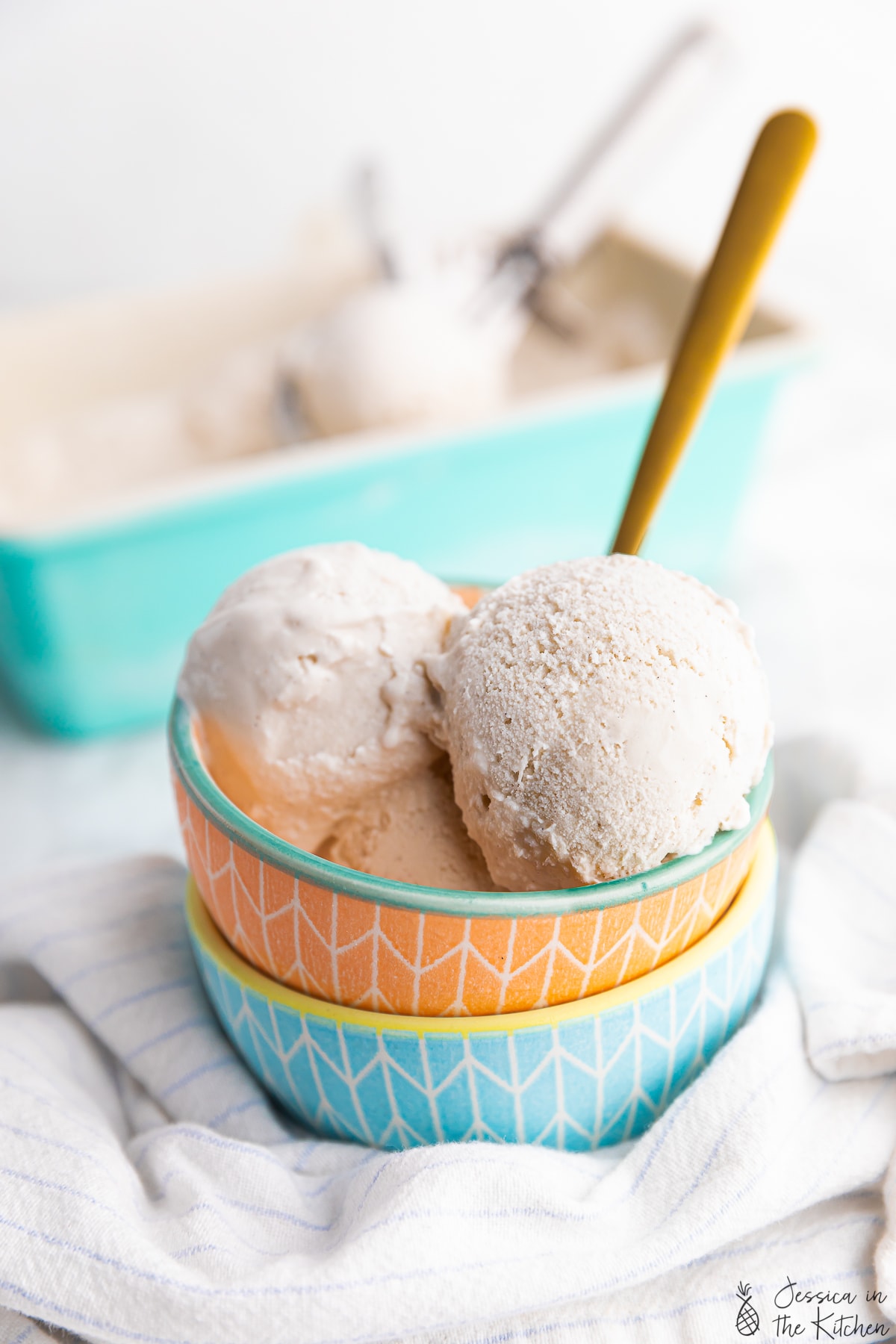 Two stacked bowls with a container of ice cream in the background.