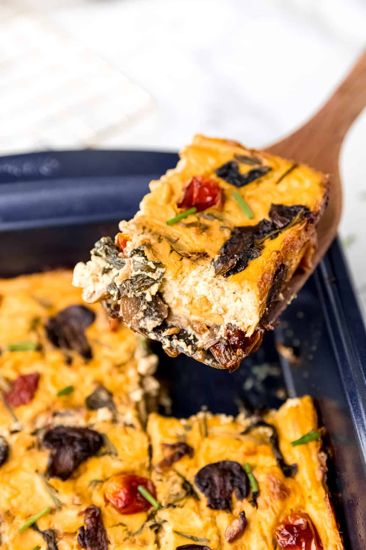 Slice of frittata being lifted out of the baking pan.