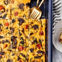 Vegan frittata in a baking sheet with fork and spoon in it.