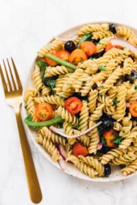 pasta salad on a plate with a fork beside it