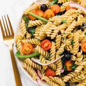 pasta salad on a plate with a fork beside it