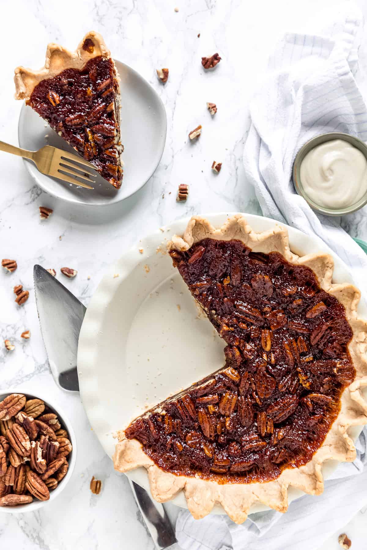pecan pie with a slice on a plate and the rest of the pie in pie dish