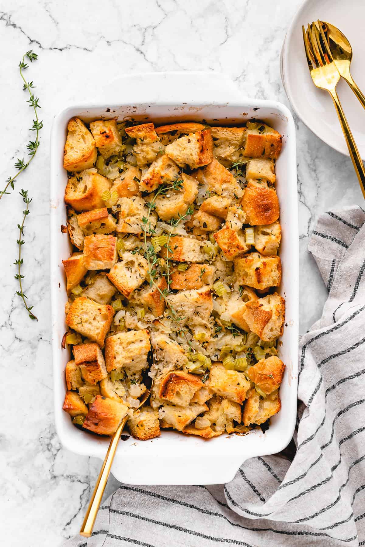 vegan stuffing in a casserole dish with a spoon in it 
