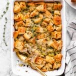 vegan stuffing in a casserole dish with a spoon and a scoop taken out