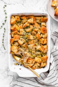 vegan stuffing in a casserole dish with a spoon and a scoop taken out