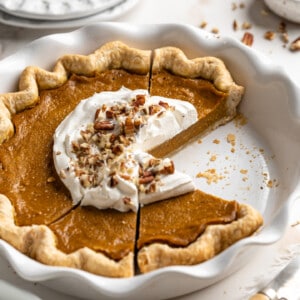 front angled shot of sliced pumpkin pie in a pie dish.