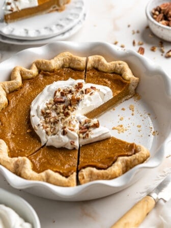 front angled shot of sliced pumpkin pie in a pie dish.