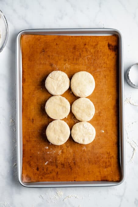 Three Unbaked Vegan Biscuits on a Baking Pan with a Liner