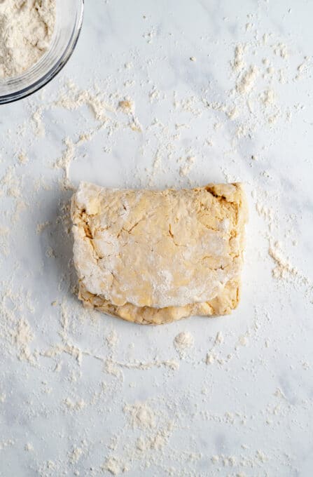 Folded Over Vegan Biscuit Dough on a Light Granite Countertop