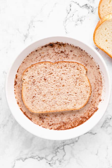 Piece of bread soaking in the milk mixture.