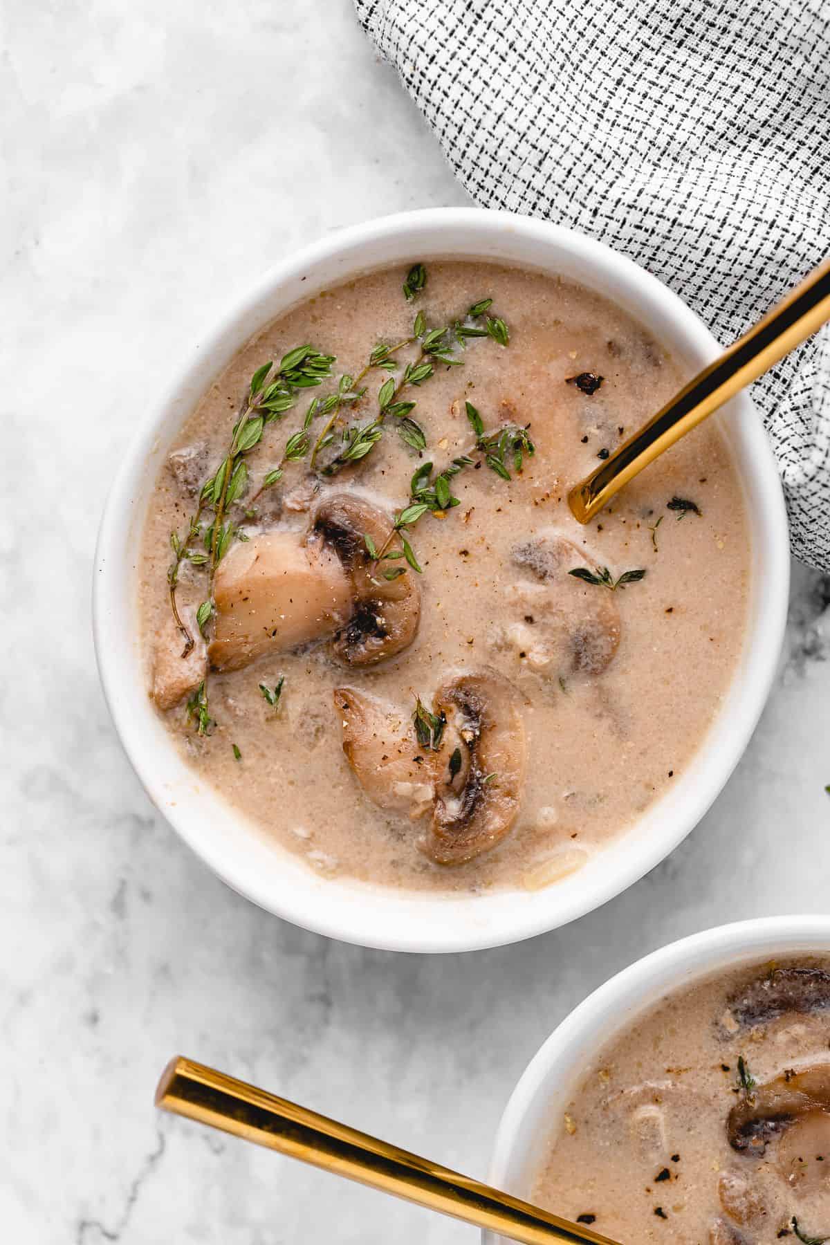 Overhead shot of mushroom soup with a gold spoon