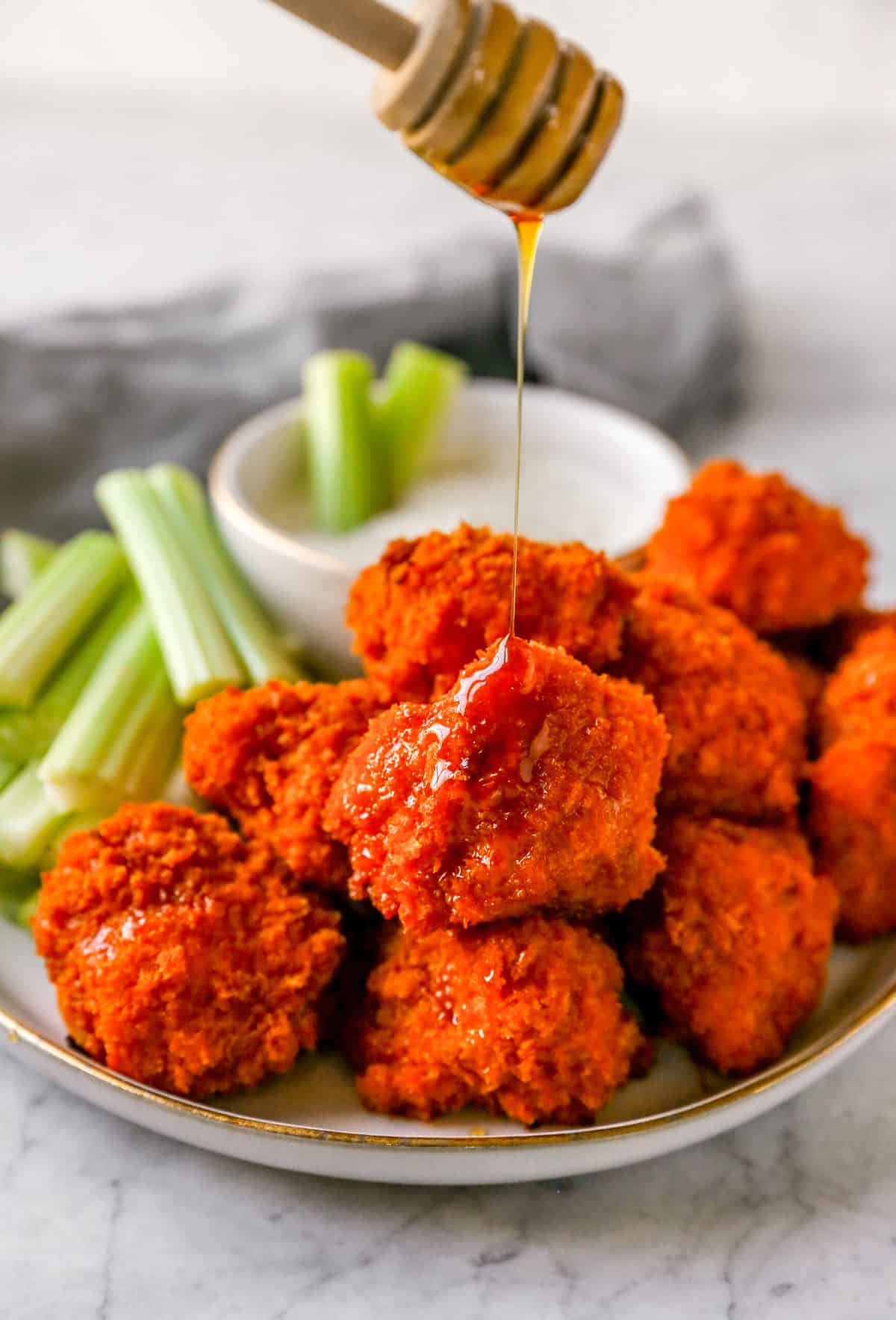 buffalo cauliflower wings on a plate with celery and ranch dip